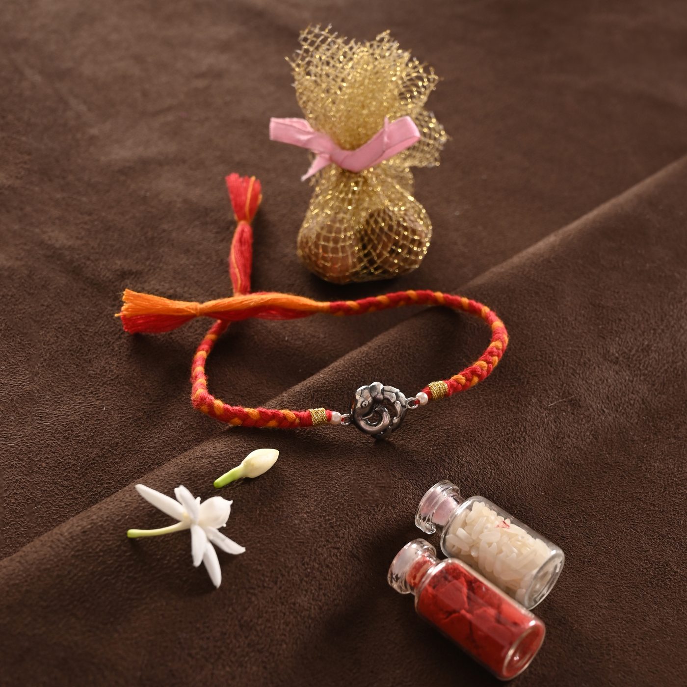 Ganesh Rakhi, red and orange thread with elephant charm