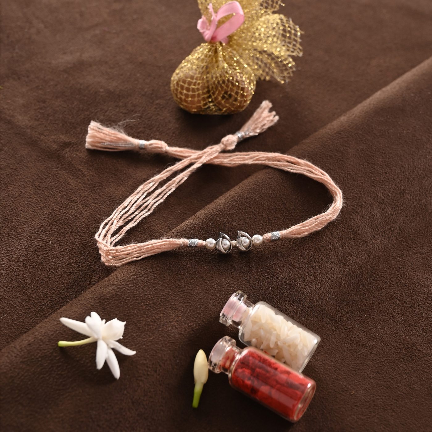 Paisley Rakhi, peach thread with twin leaf charms