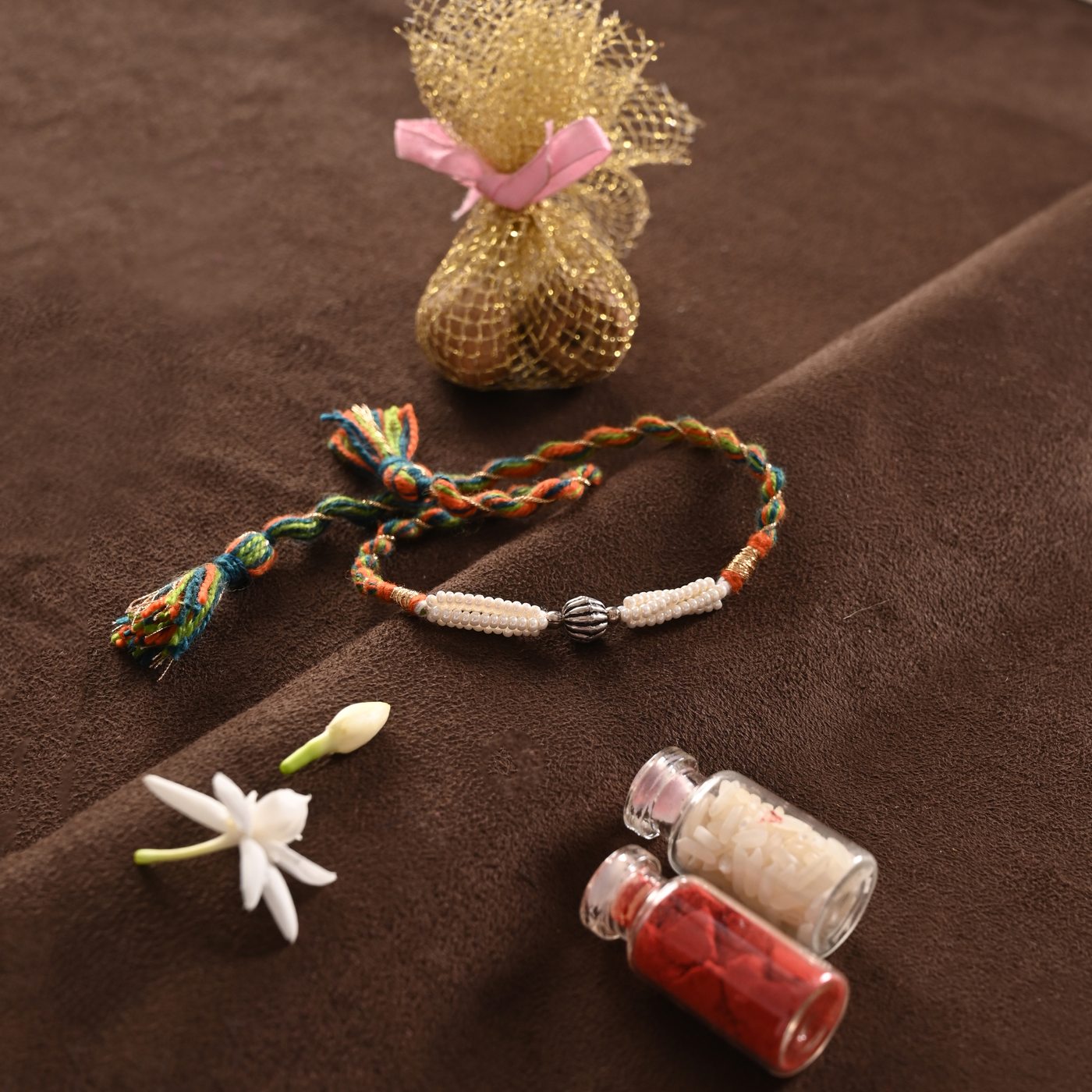 Rangoli Rakhi, multicolour thread with pearls and silver charm