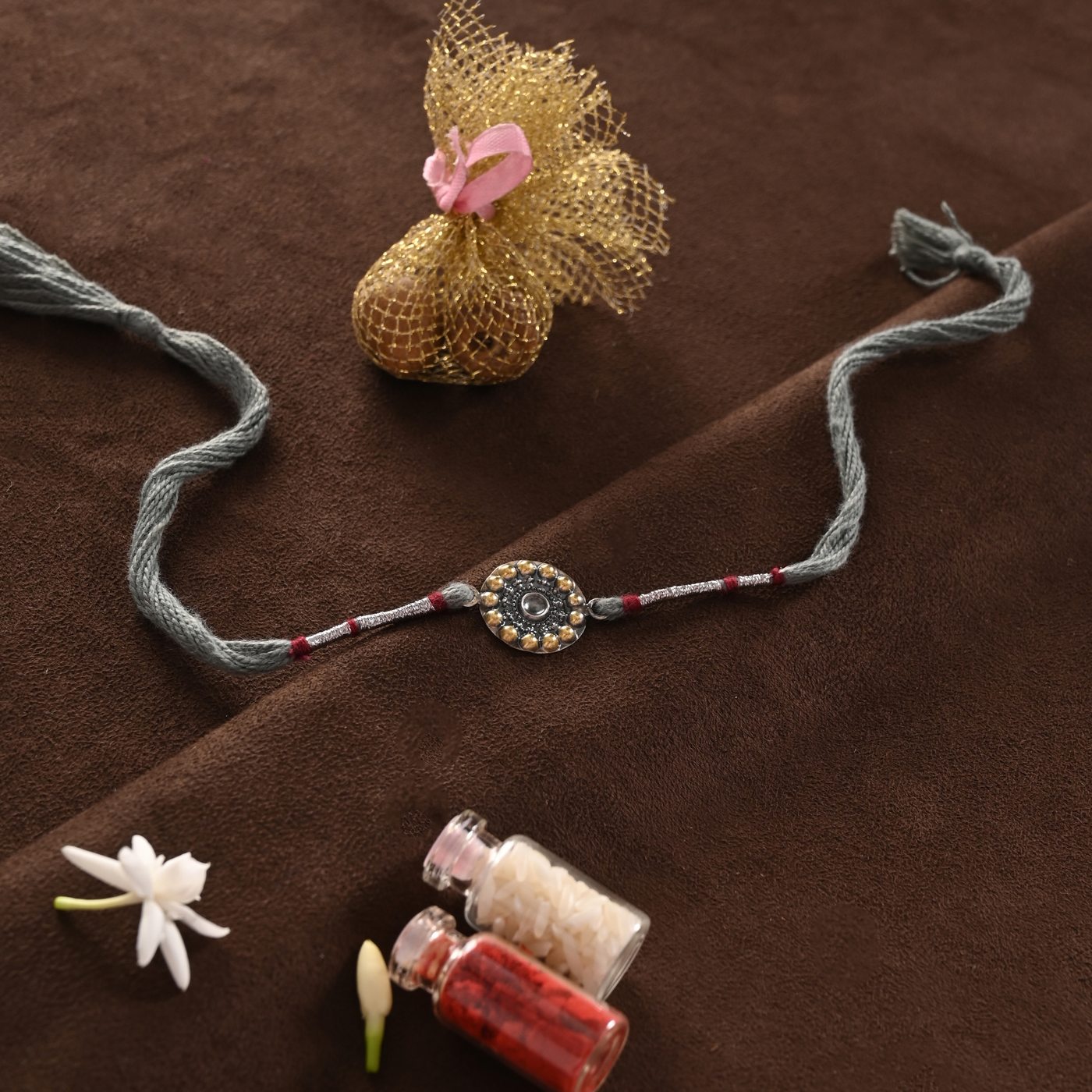 Surya Rakhi, grey thread with round sun medallion charm